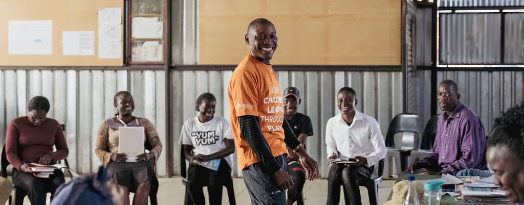A group of adult parenting students smile hugely during their latest lesson.
